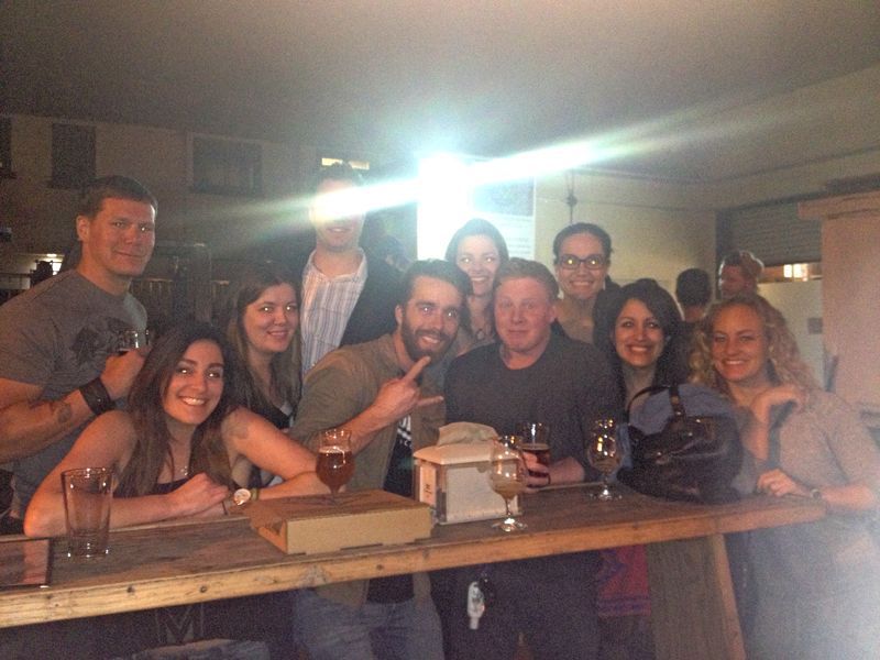 Person taking photo in mirror, indoors; black and white.