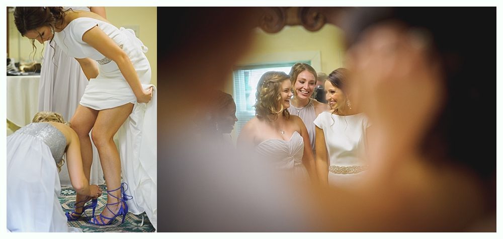 Bride and groom embrace on a beach. Ocean, blue sky, and tree branch in the foreground.