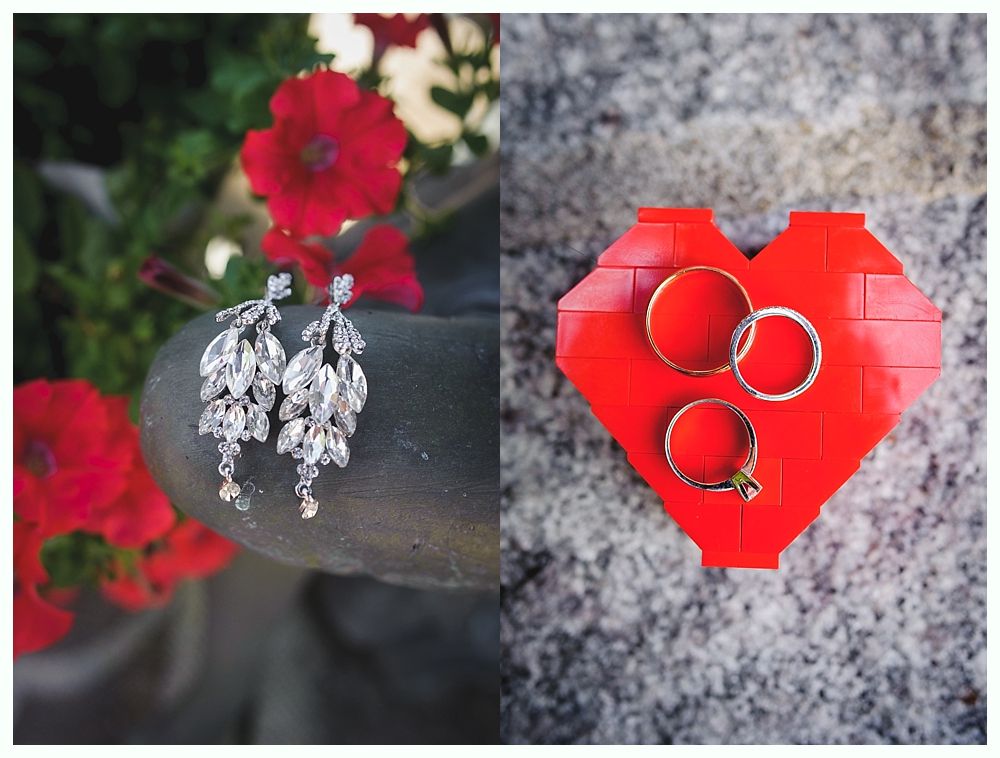 Wedding party on a beach with blue sky. Bride and groom embrace, others stand nearby. Dark blue dresses and jackets.