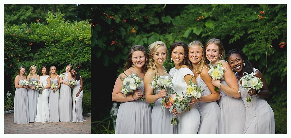 Couple on boardwalk by ocean, framed by beach plants under a blue sky with clouds.