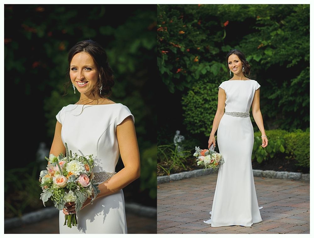 Bride with arms up, making a funny face, groom looking at his hand, cake cutting in background.