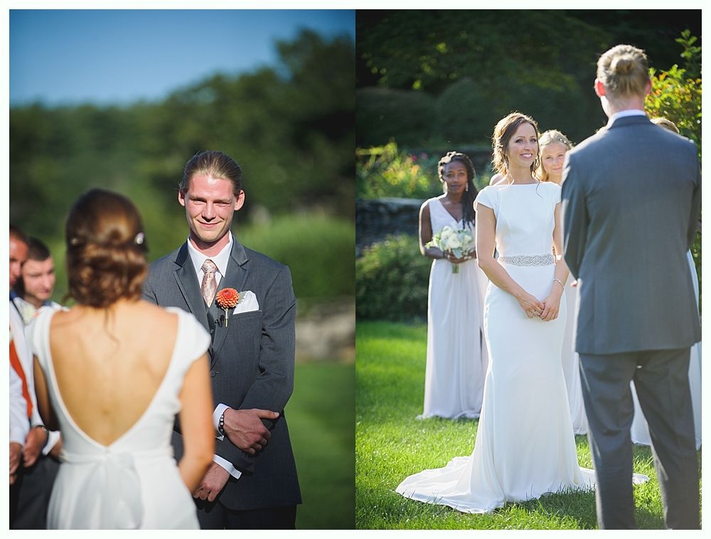 Bride with arms up, making a funny face, groom looking at his hand, cake cutting in background.