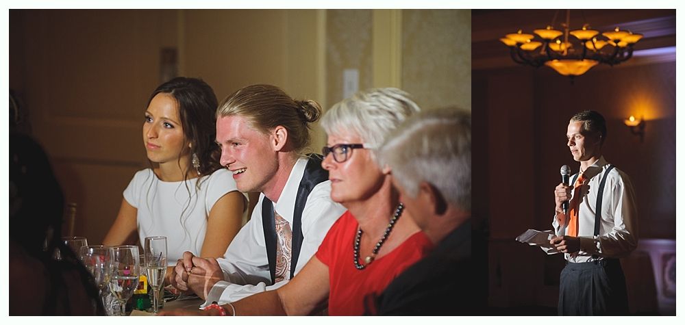 Bride with arms up, making a funny face, groom looking at his hand, cake cutting in background.