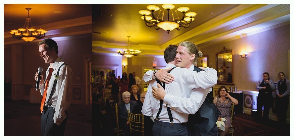 Bride with arms up, making a funny face, groom looking at his hand, cake cutting in background.
