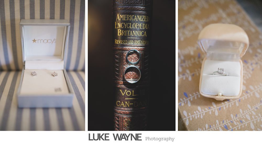 Man adjusting shirt cuffs, then smiling, wearing a gray suit with lavender bow tie and pocket square.