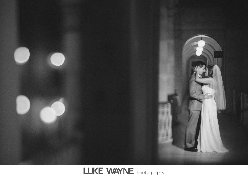 Bride and bridesmaids in purple dresses at a bar, toasting with drinks.