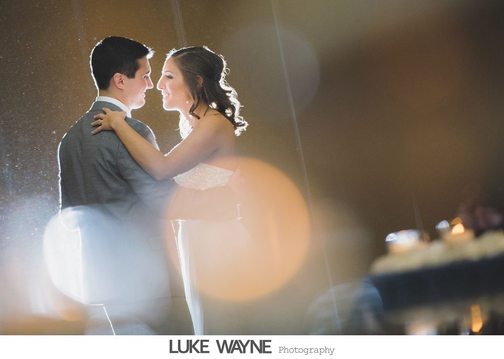 Wedding reception details: cake, flowers, wine, purple and white decor.