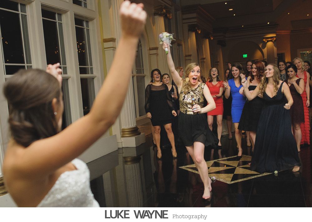 Wedding reception details: cake, flowers, wine, purple and white decor.