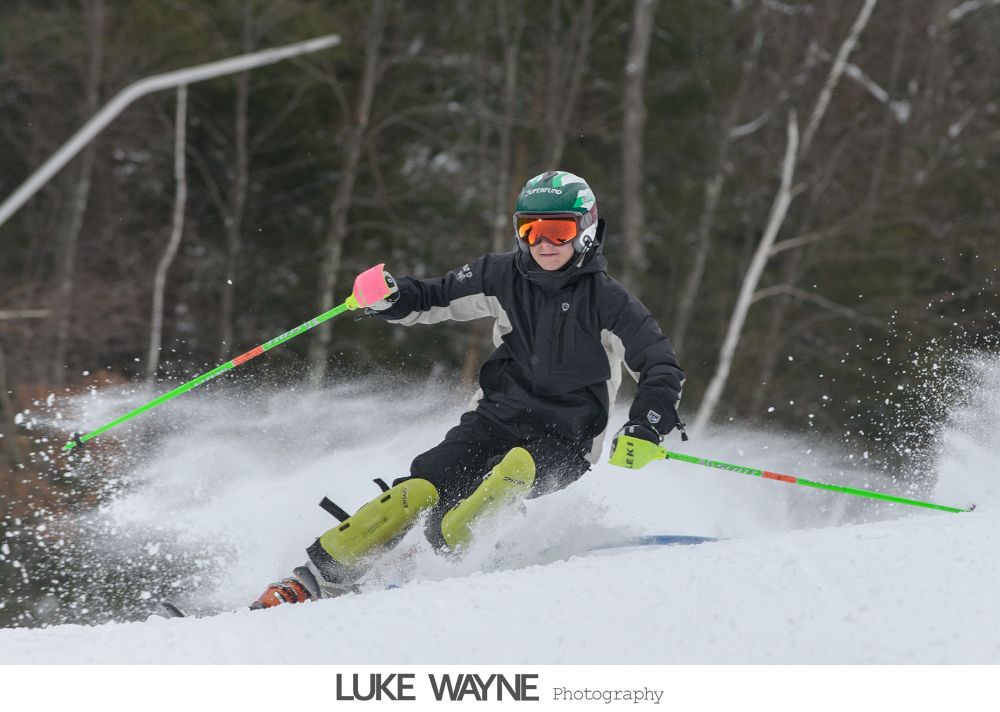 Woman wearing a hat with veil and feathers, in black and white.