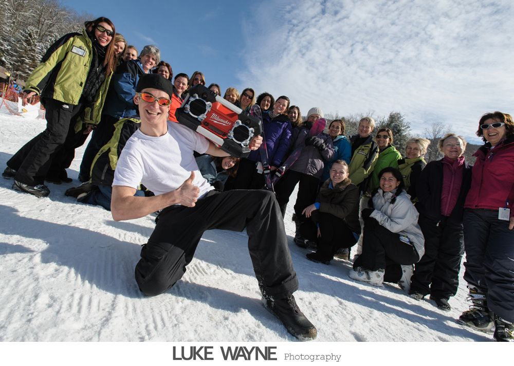Woman in a button-down shirt adjusts a headpiece, looking at her reflection in a mirror. Black and white photo.