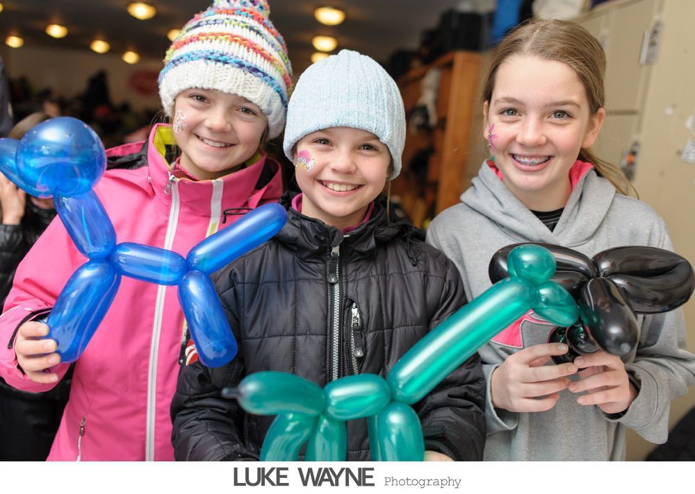Bride and groom cross a city street, yellow school bus and traffic in the background.