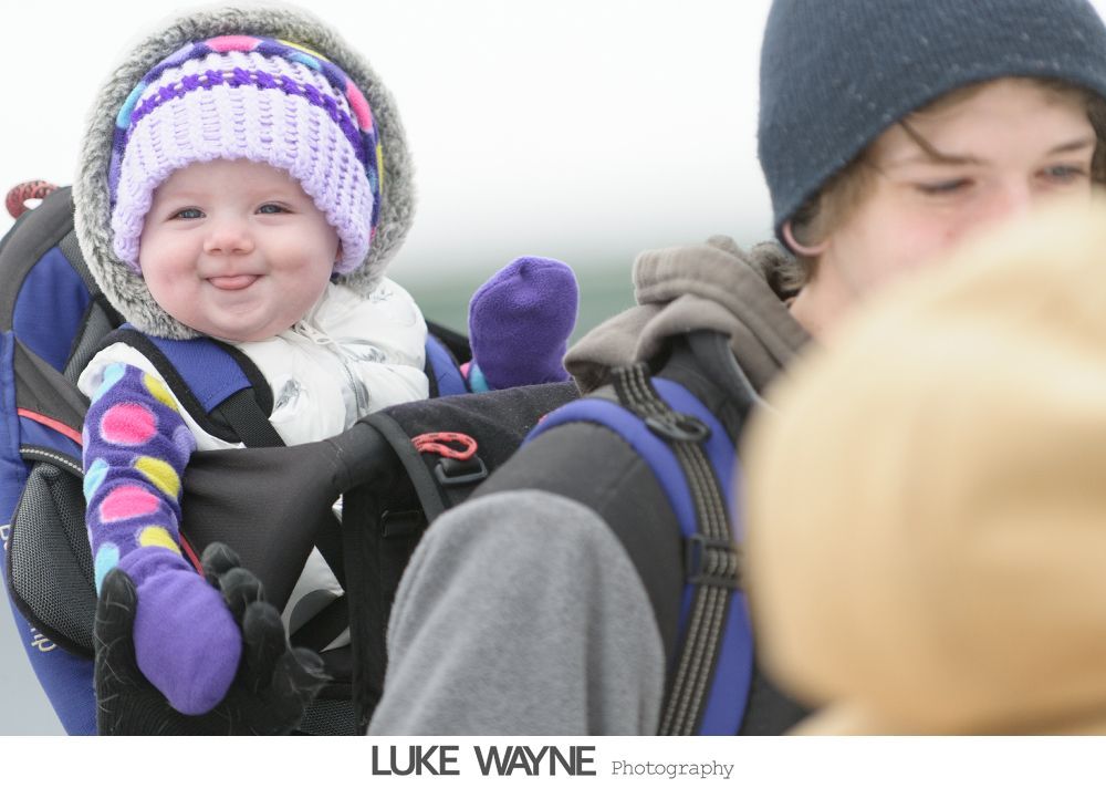 Four-panel photo of a couple at a bar. They pose with a whiskey bottle, with varying expressions: happy, playful, and drinking.