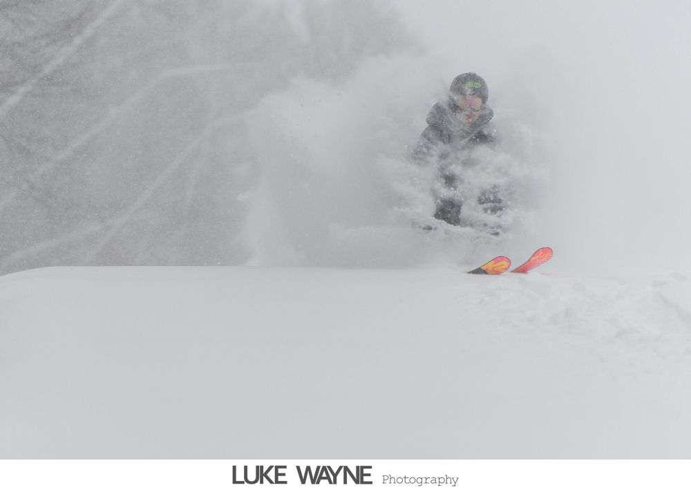 Wedding party posing in bar: bride on bar, groomsmen sprawled on floor, expressions of exhaustion.
