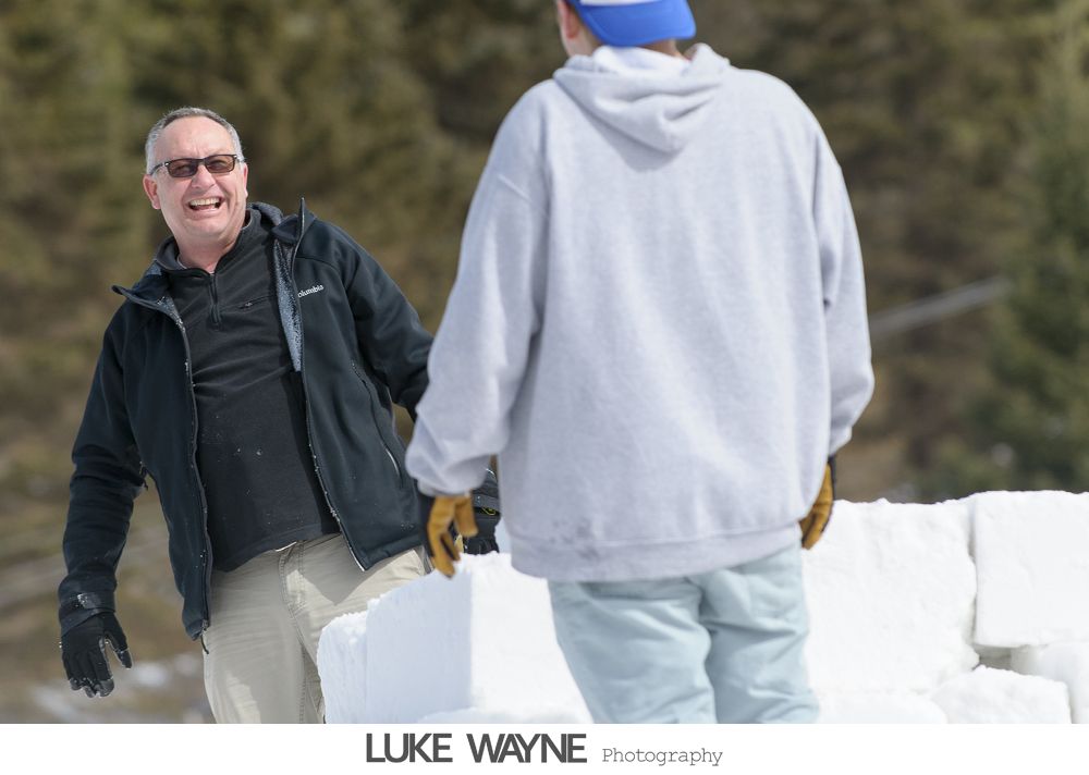 Bride and bridesmaids in purple dresses at a bar, toasting with drinks.