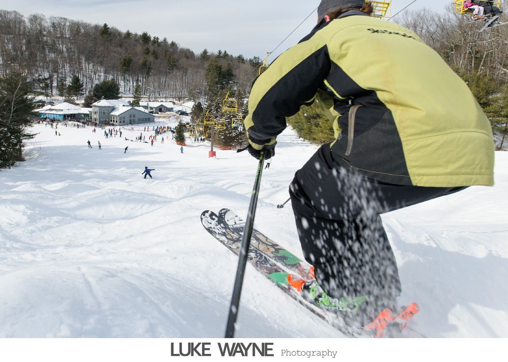 Silhouetted wedding couple and officiant in front of an arched window.