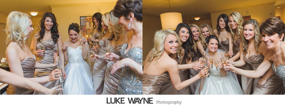 Bridesmaids celebrate with champagne in a room. The bride in a white gown is the focus.