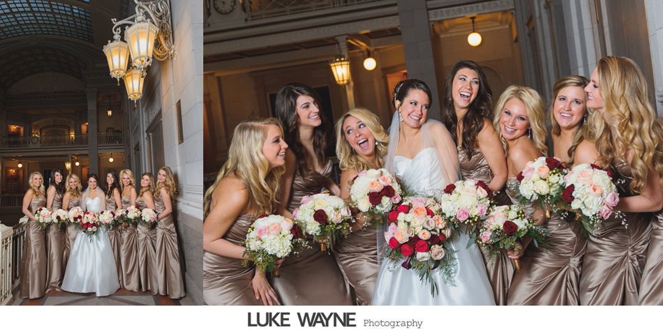 Bride and bridesmaids pose with bouquets. Champagne-colored gowns, smiles. Indoors, ornate architecture.