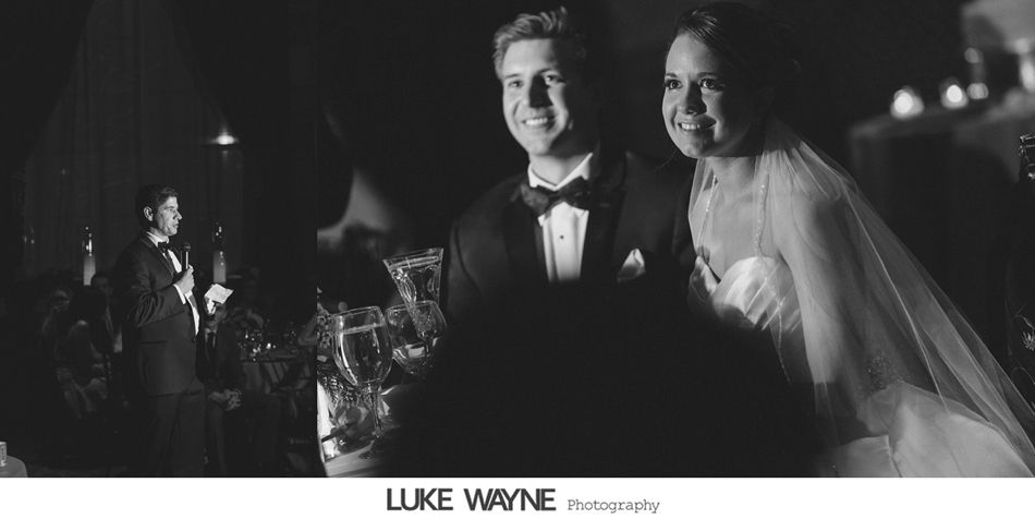 Bride and groom smiling at their wedding reception, band in background.