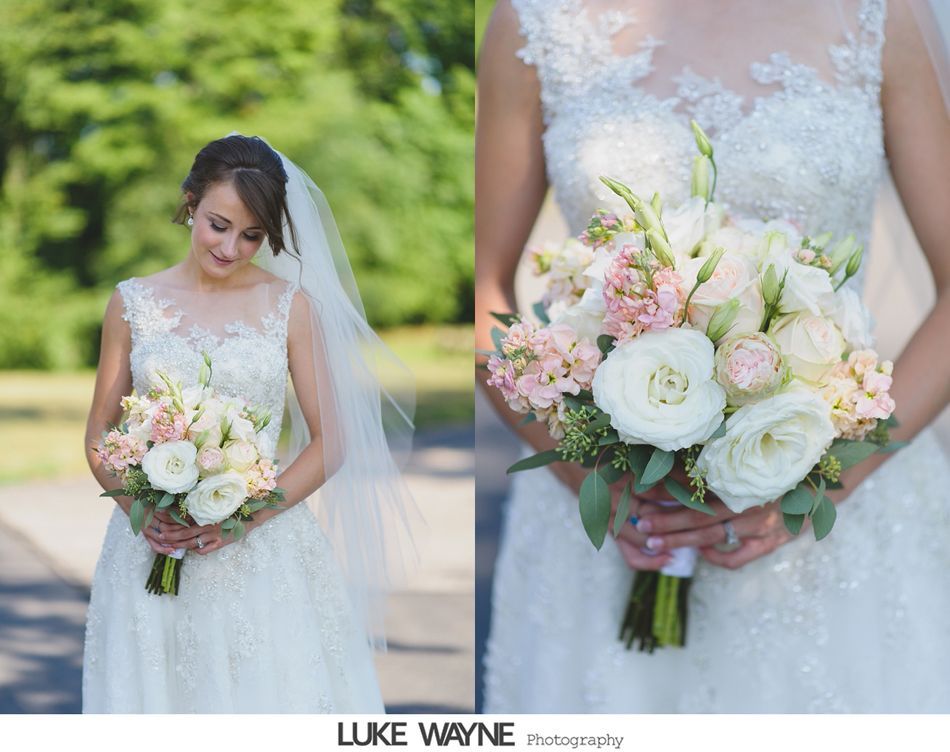 Bride in a white lace wedding dress holding a bouquet of white and pink flowers.