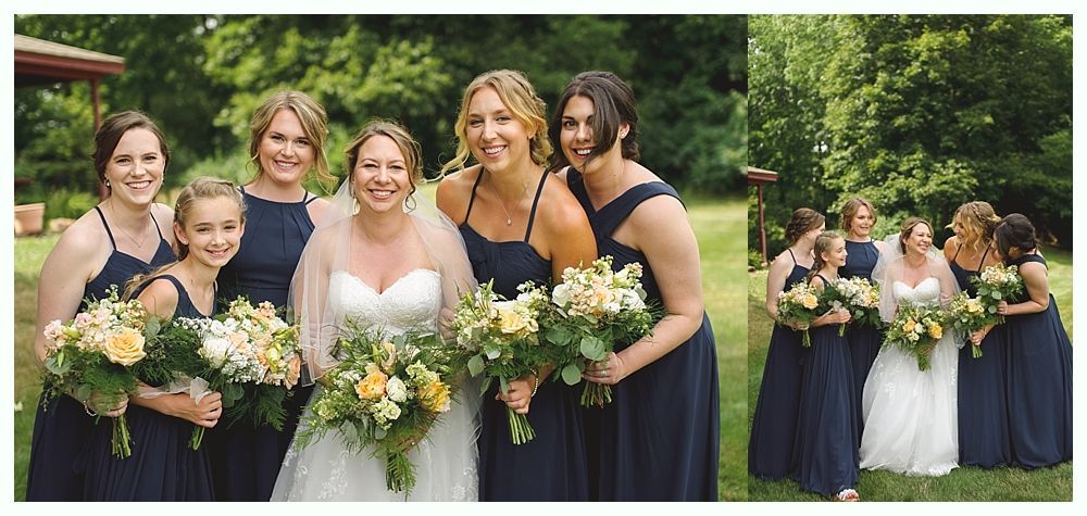 Bride and bridesmaids posing in a garden, all wearing dark blue dresses and holding bouquets.