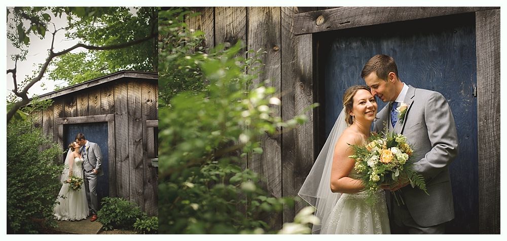 Wedding couple by a blue door, the bride in a white dress and veil, the groom in a gray suit, holding a bouquet, smiling.