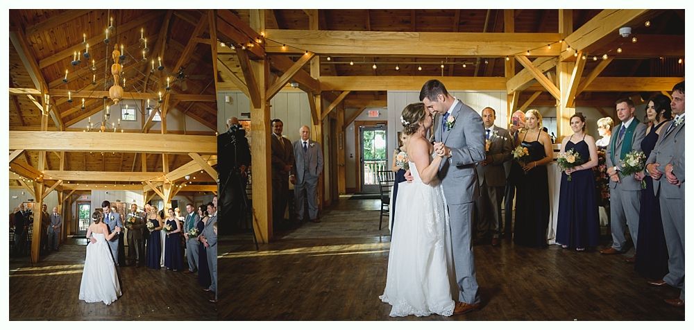 Bride and groom dance at a wedding reception in a rustic barn, surrounded by guests.