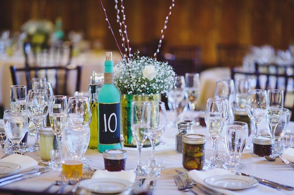Wedding table setting with centerpieces of flowers and a painted bottle numbered 10.