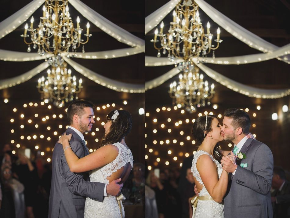 Couple dancing under chandeliers and string lights at a wedding reception.