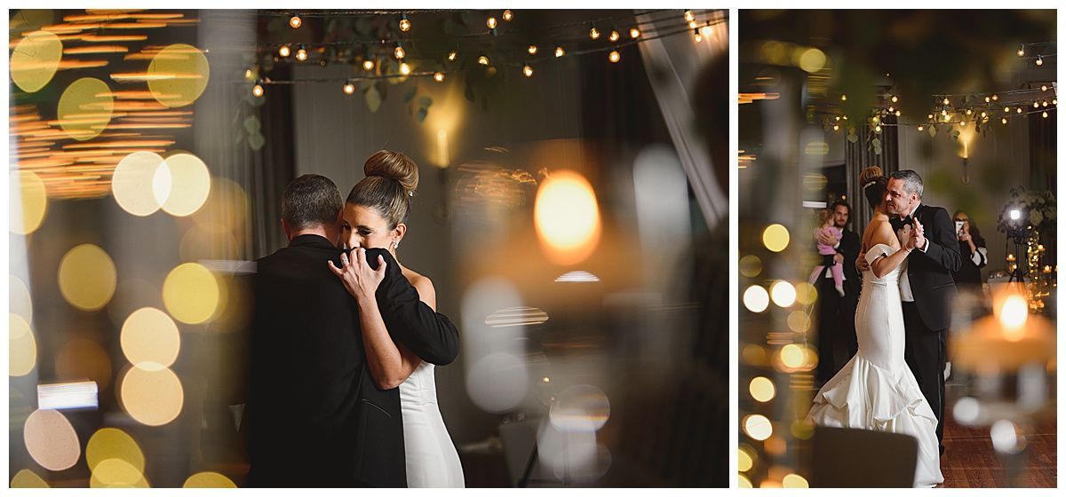 A couple dances at a wedding reception, with a blurred background of lights and greenery.