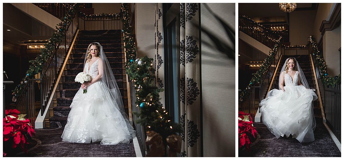 Bride in a white gown descends a staircase decorated with Christmas garland.
