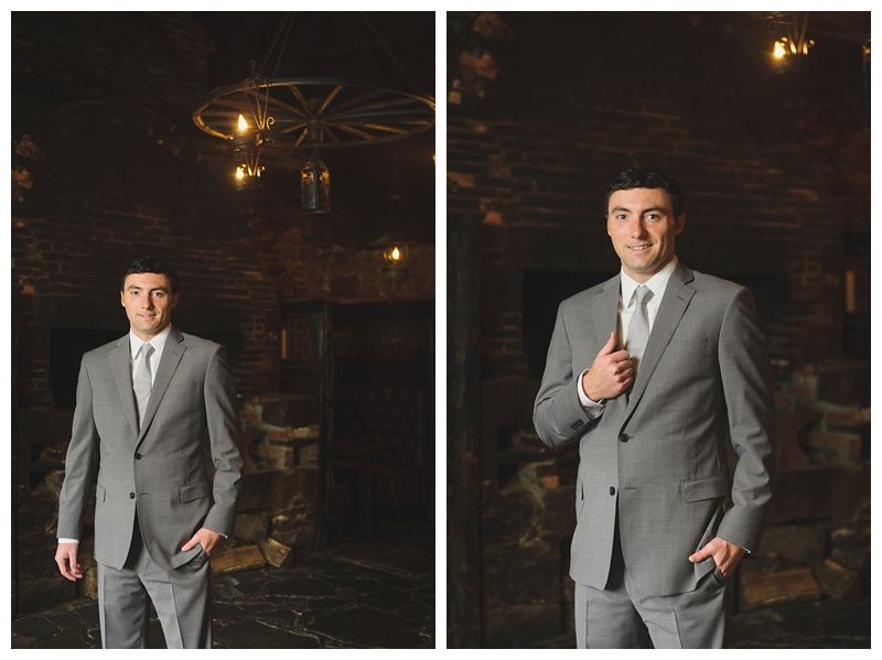 Couple on boardwalk by ocean, framed by beach plants under a blue sky with clouds.