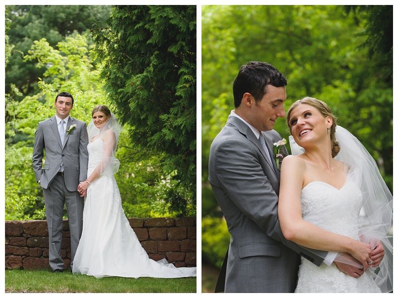 Bride with arms up, making a funny face, groom looking at his hand, cake cutting in background.