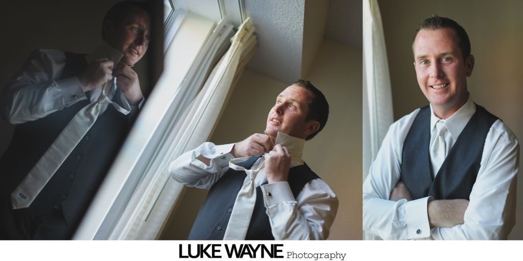 Man in a vest and tie adjusts his tie, then smiles with arms crossed, next to a window.