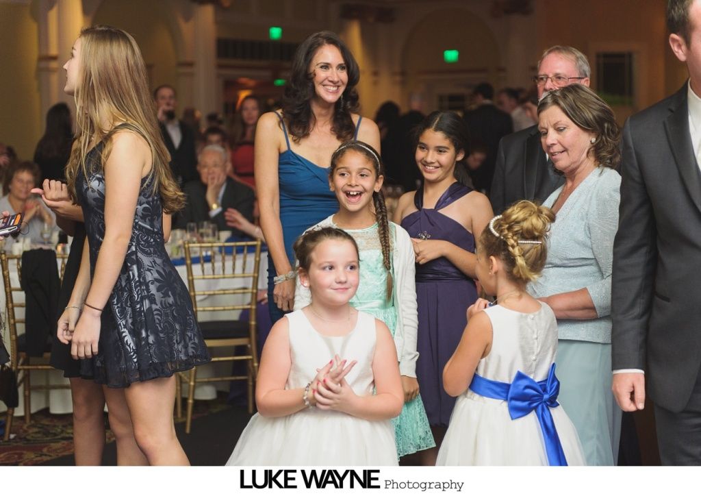 People at a formal event, including several girls in dresses and a woman in a blue gown, all smiling.