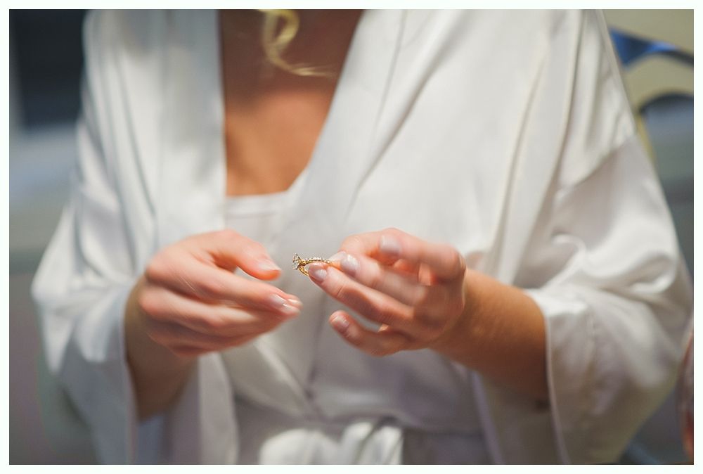 Bride and bridesmaids in navy dresses hold bouquets, posing outdoors.