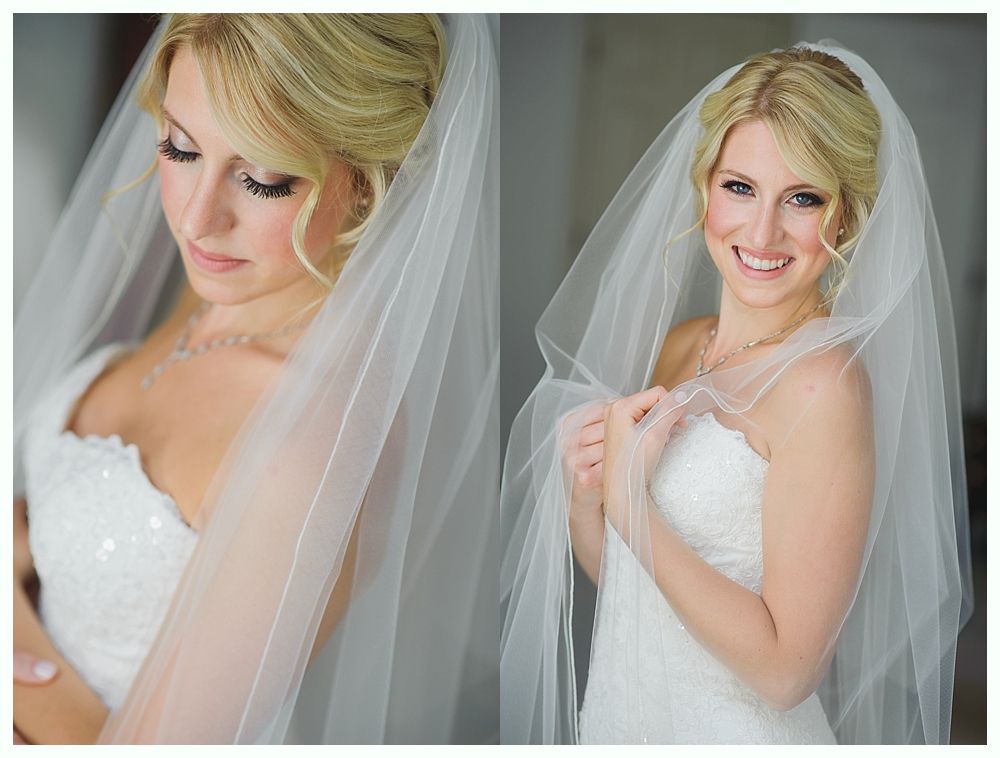 Bride and groom embrace on rocks by the ocean at sunset. The groom wears a blue suit, the bride a white dress.
