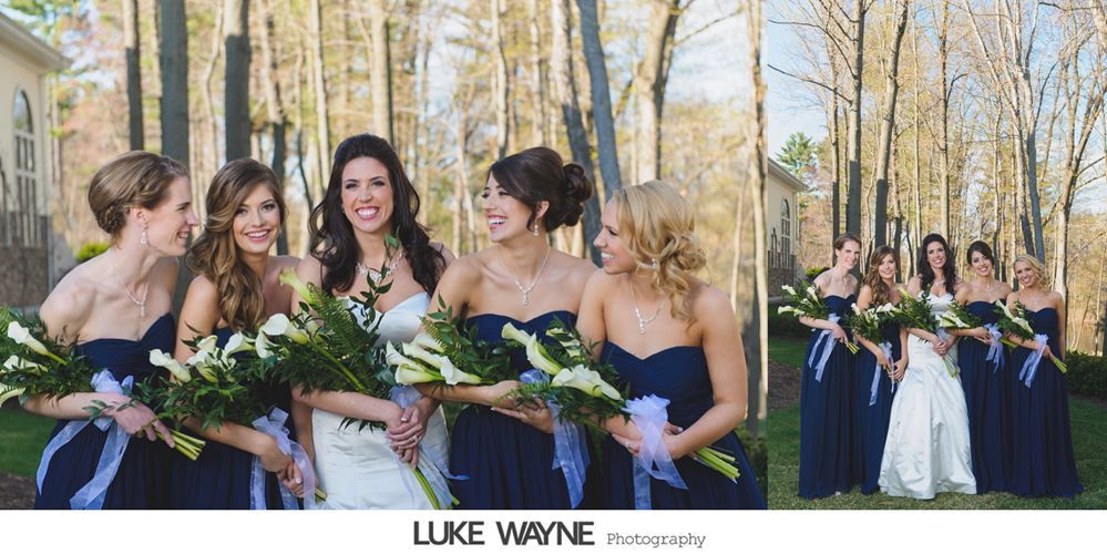 Bridesmaids in navy dresses with calla lily bouquets, smiling outdoors with the bride.