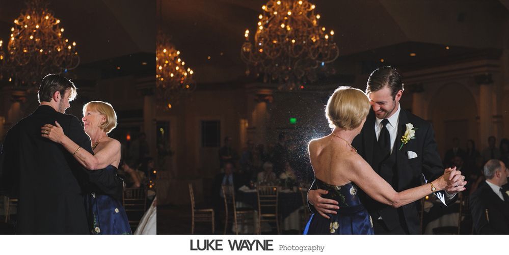 Two couples dancing in a dimly lit ballroom with chandeliers.