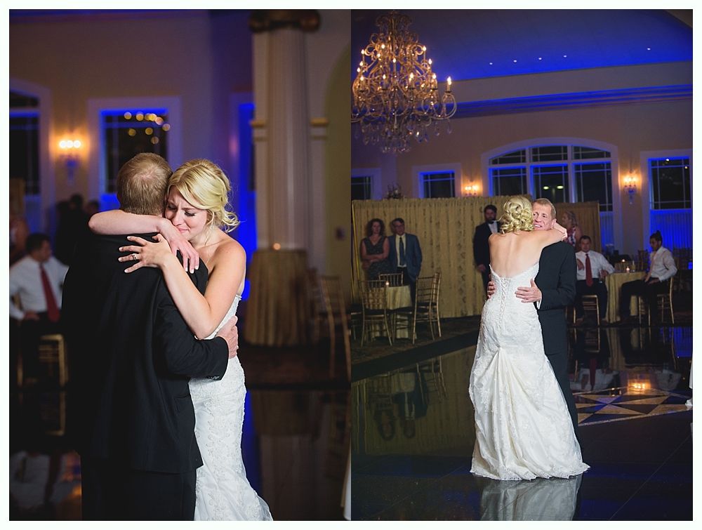 Bride with arms up, making a funny face, groom looking at his hand, cake cutting in background.