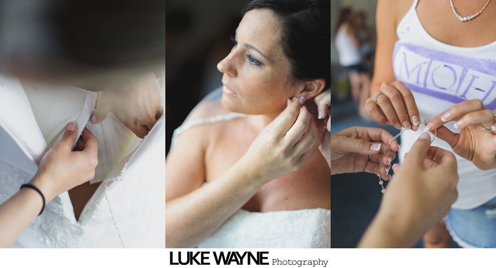 Bride holding bouquet, smiling in a room. Bridesmaids in the background.