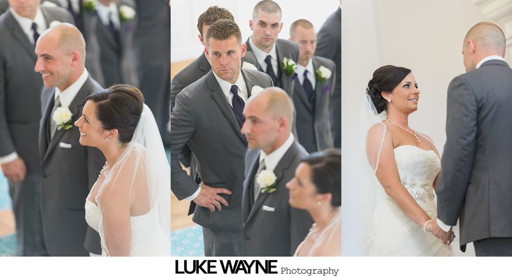 Wedding party posing on a road, with the bride and groom at the center. Some are smiling, others are making silly faces.