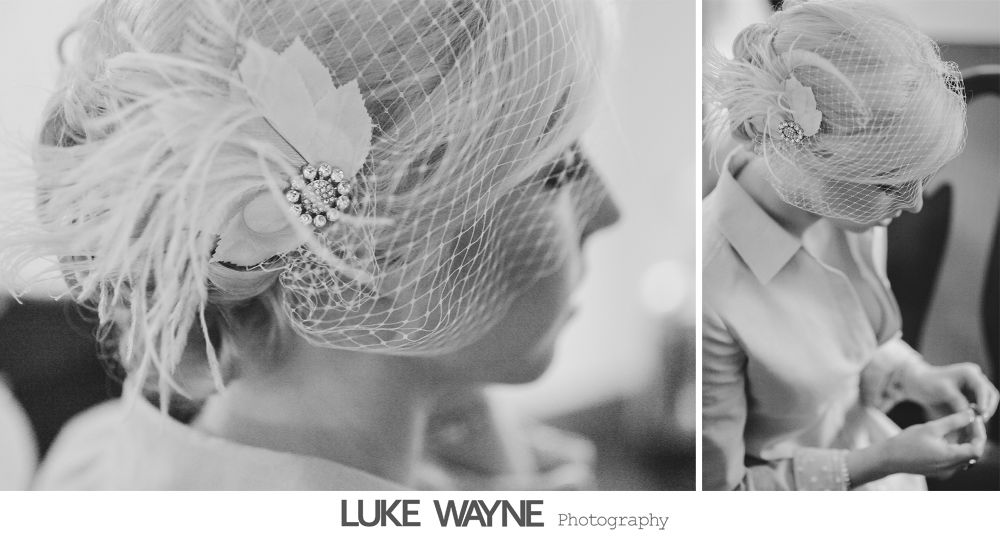 Woman wearing a hat with veil and feathers, in black and white.