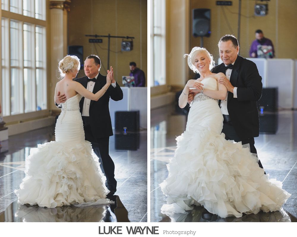 Bride and groom dancing at wedding reception; bride in white gown, groom in tuxedo, by DJ booth.