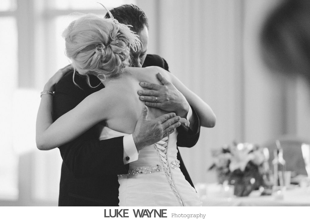 Bride and groom embrace, wedding reception. Black and white.