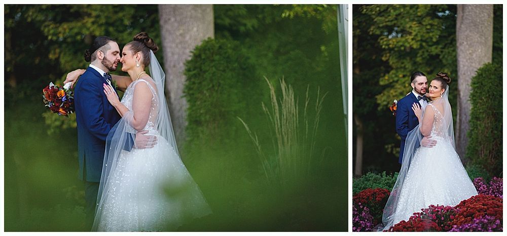 Wedding couple in front of greenery. Bride in white dress, groom in blue suit.