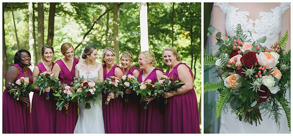 A bride and bridesmaids in magenta dresses hold bouquets, smiling in a forest.