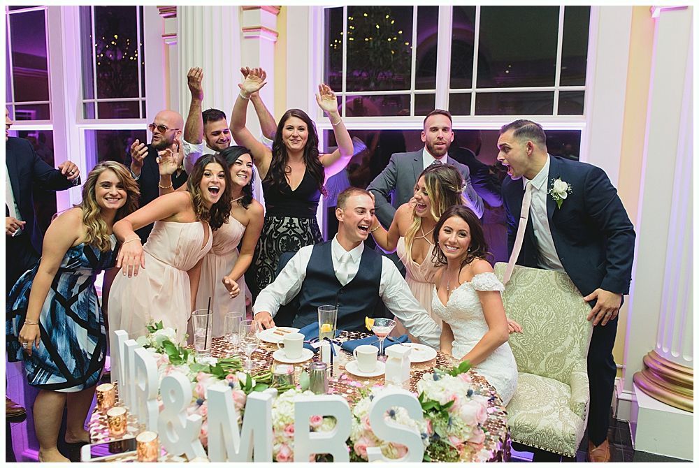 Wedding reception group photo. Bride and groom at table with