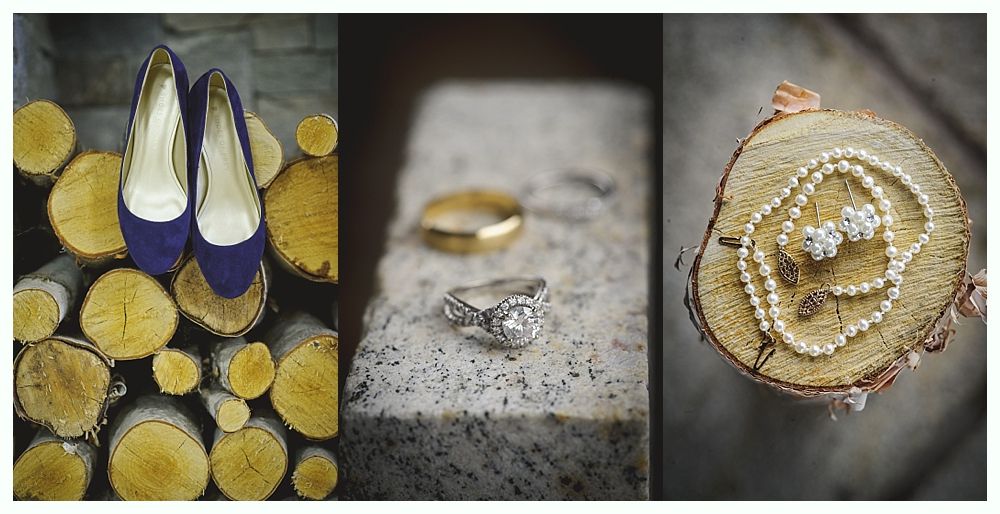 Wedding details: blue shoes on logs, rings on stone, pearl necklace on wood slice.