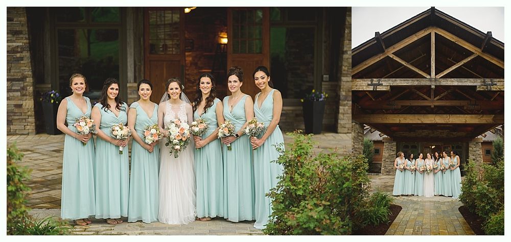 Wedding party outside a stone building. Bridesmaids in light blue dresses, bride in white. Wooden roof structure.