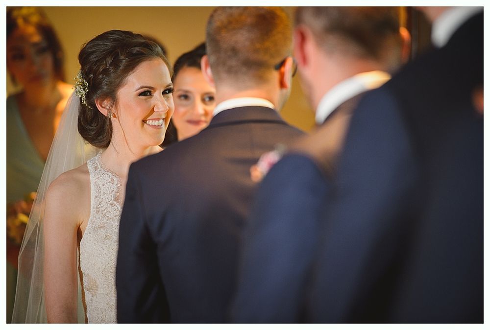 Bride smiling at groom during wedding ceremony.
